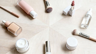 Clean beauty makeup products including powder, blush, and brushes on a neutral surface.